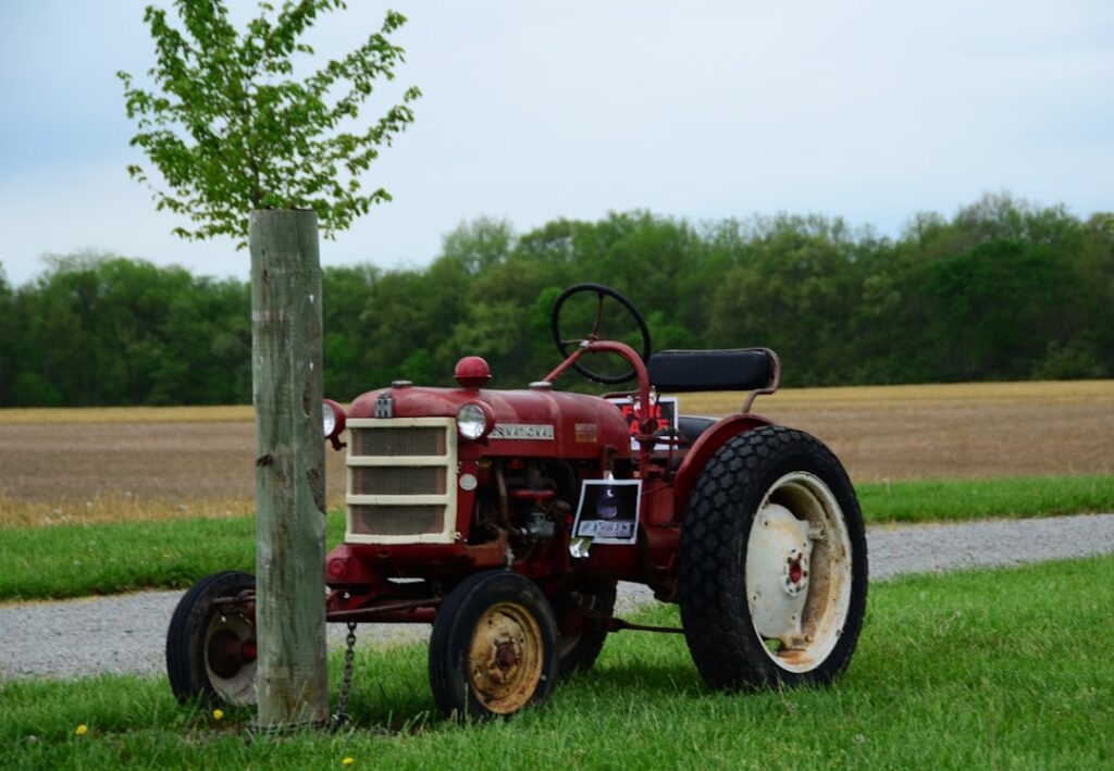 Um Trator Vermelho Estacionado Ao Lado De Uma Arvore ZGw4 jcq5LI