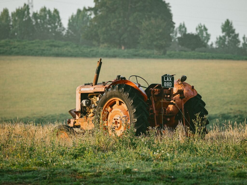 Trator Oxidado Velho Em Um Campo Gramineo M3Mq VFZDAM