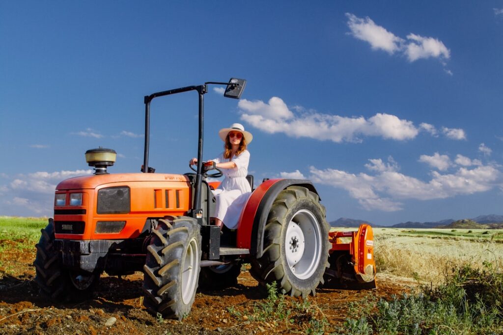 Mulher Dirigindo Um Trator Laranja Em Um Campo mpDZwiN6Gzo