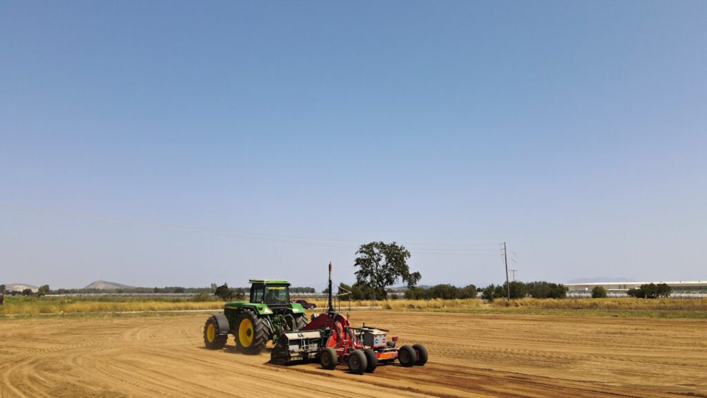 Trator Verde Puxando Equipamentos Agricolas Atraves De Um Campo VCZ0GpB0reQ