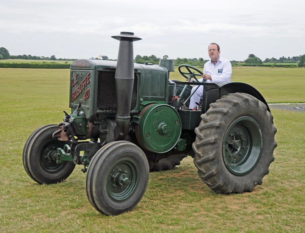 Um Homem Sentando Ligado Um Trator Em Um Campo YlQZI8diw3o